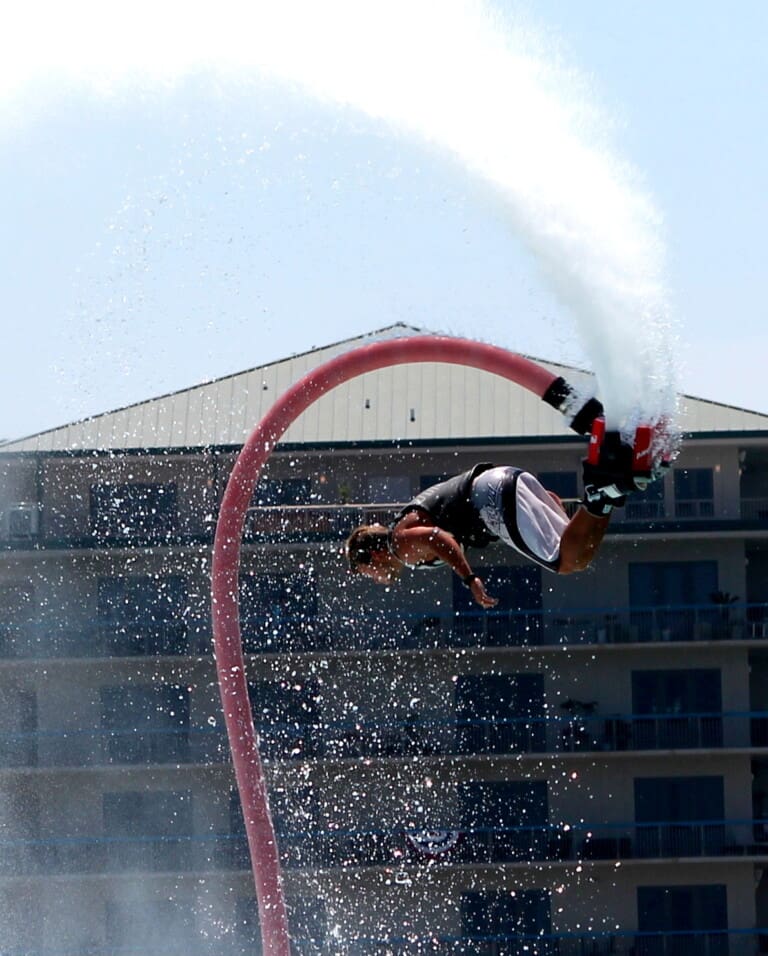 Destin Vacation Sports | Beach Condos in Destin #Flyboarder spinning in the air propelled by a water jetpack