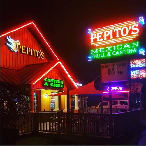 Neon-lit Pepito's Mexican Grill & Cantina storefront at night with red roof trim and bright green sign reading Cantina & Grill outside the entrance.